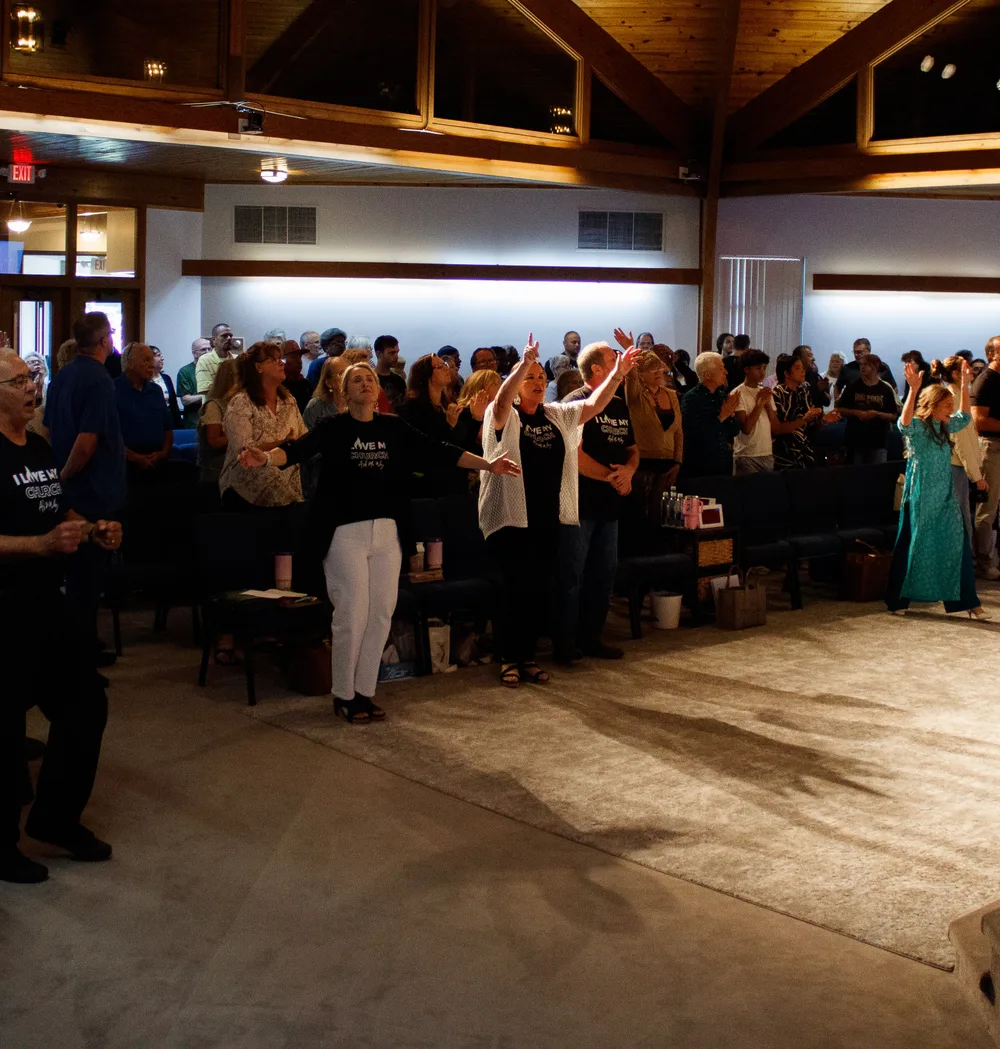 The congregation at Redeemed Life Church in worship, hands raised