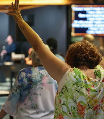 Hands raised across a row of the congregation on a Sunday
